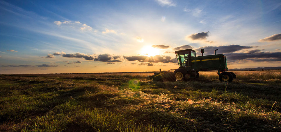 The sun sets over a tractor in a southwestern Oklahoma field.